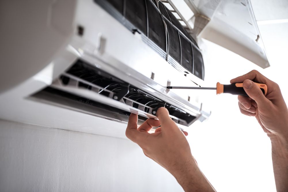 A technician is fixing an air conditioning unit, showcasing appliance repair services in Washington, DC.